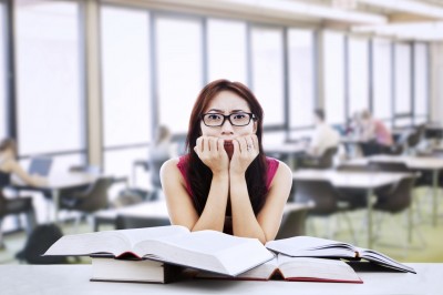 Anxious student leaning over textbooks
